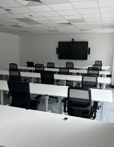 Video conferencing room with rows of desks
