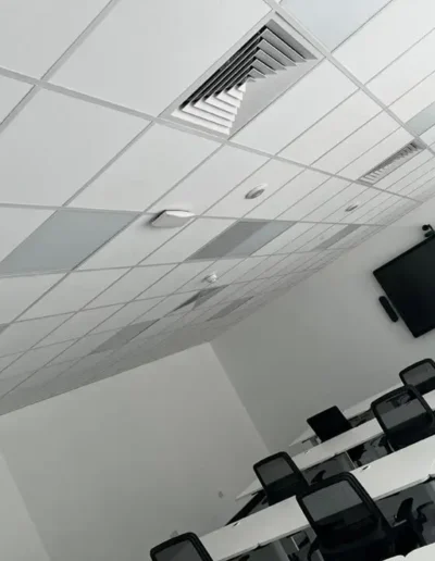 Video conferencing room with rows of desks and chairs